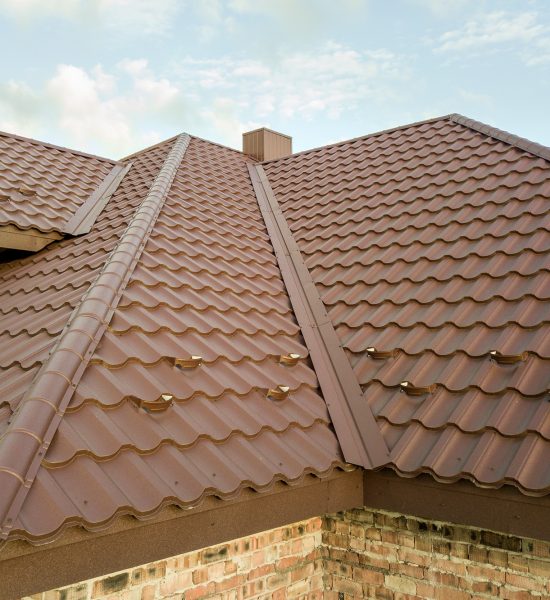 Detail of house roof structure covered with brown metal tile sheets Detail of house roof structure covered with brown metal tile sheets
