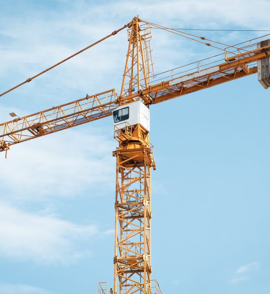 Yellow construction crane with cabin. Lifting of cargo. Construction machinery concept Yellow construction crane with cabin. Lifting of cargo. Construction machinery concept